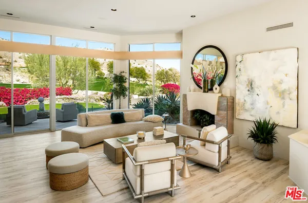 a living room with fireplace furniture and a large window