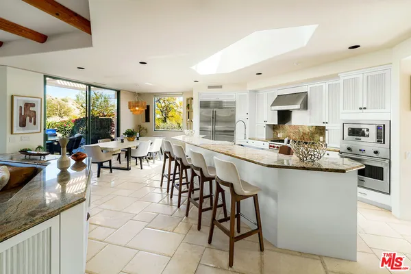a large kitchen with kitchen island granite countertop lots of counter space and dining table
