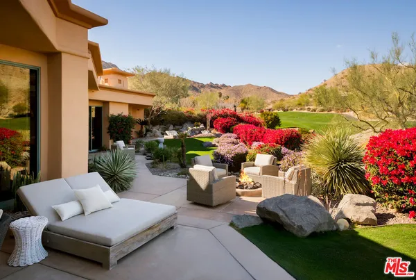 a view of a patio with couches table and chairs potted plants and a large tree