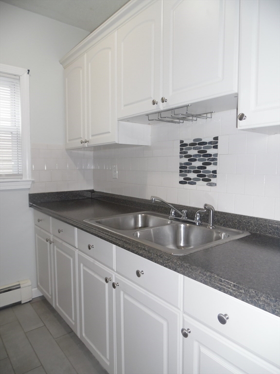1226 North Main Street, Unit 1 Fall River, MA 02720 - Photo 6 of 10 a kitchen with granite countertop white cabinets and a sink
