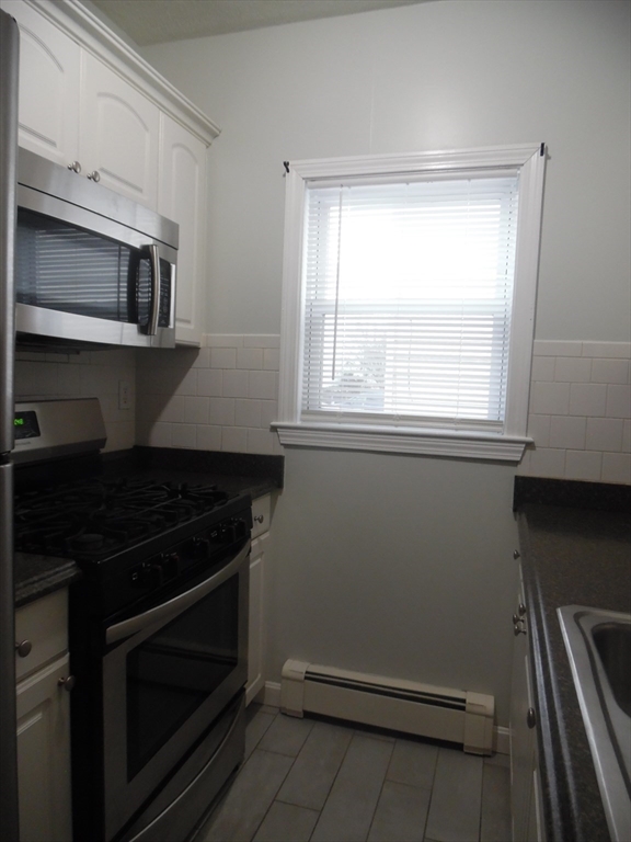 1226 North Main Street, Unit 1 Fall River, MA 02720 - Photo 7 of 10 a kitchen with granite countertop a stove and a microwave