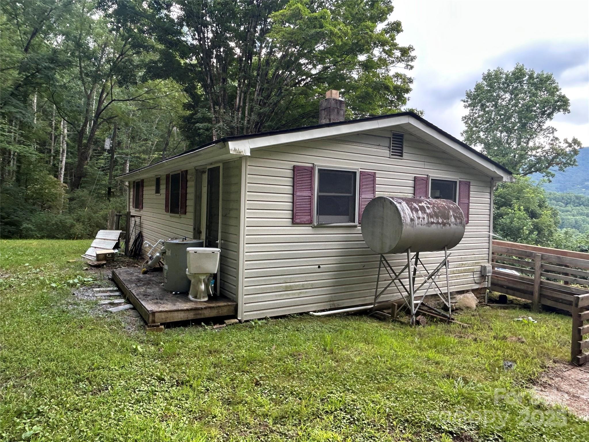 103 Cambridge Way Waynesville, NC 28786 - Photo 2 of 6 a view of backyard of house with outdoor seating and green space