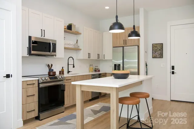 a kitchen with stainless steel appliances a sink a stove and cabinets