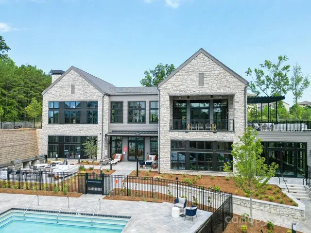 a view of house with swimming pool and outdoor seating