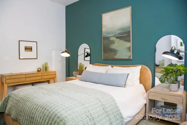 a bedroom with a bed and a painting on the wall