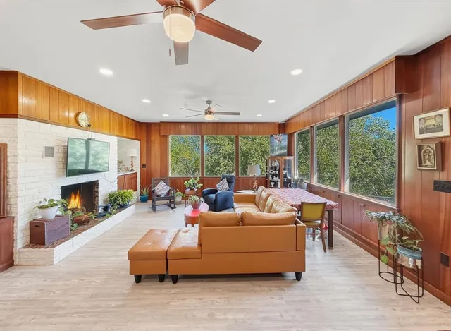 a living room with fireplace furniture and a large window