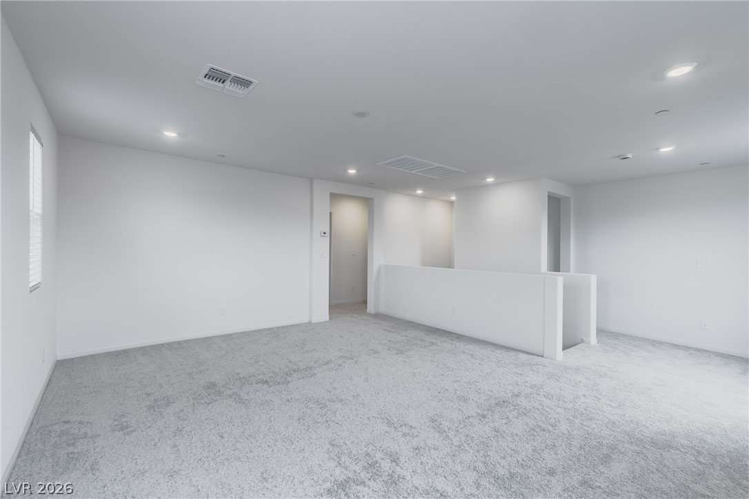 3765 Osiris Avenue Henderson, NV 89044 - Photo 13 of 40 Empty room with light colored carpet and recessed lighting