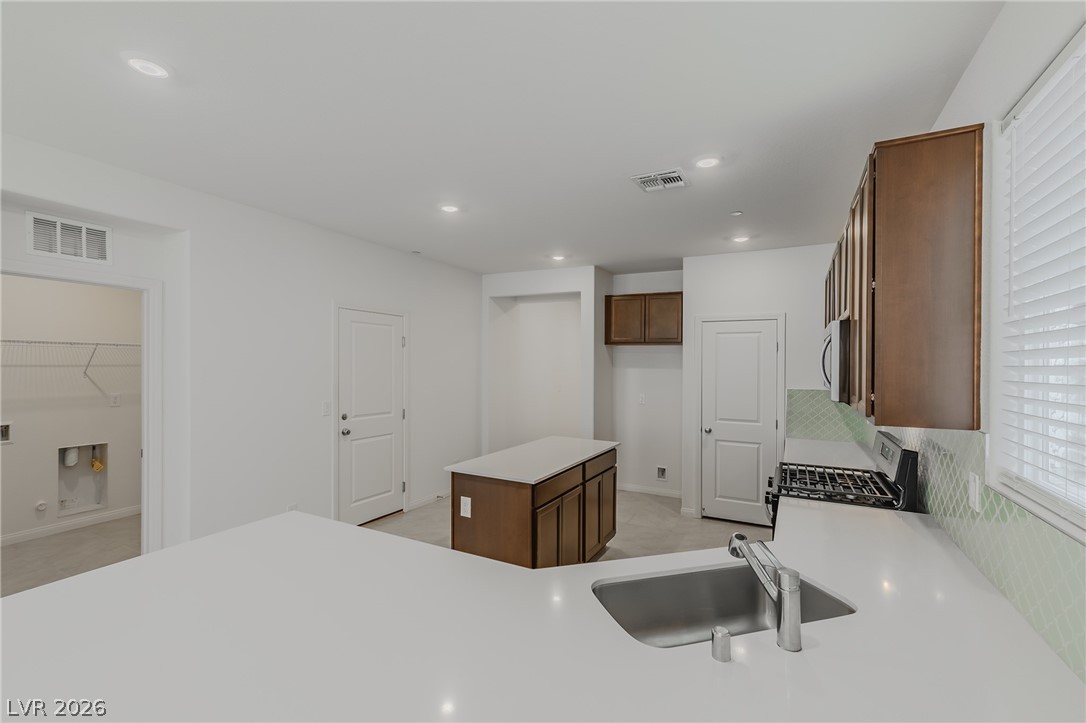 3765 Osiris Avenue Henderson, NV 89044 - Photo 36 of 40 Kitchen with a center island, stainless steel appliances, wood finish cabinets, and recessed lighting