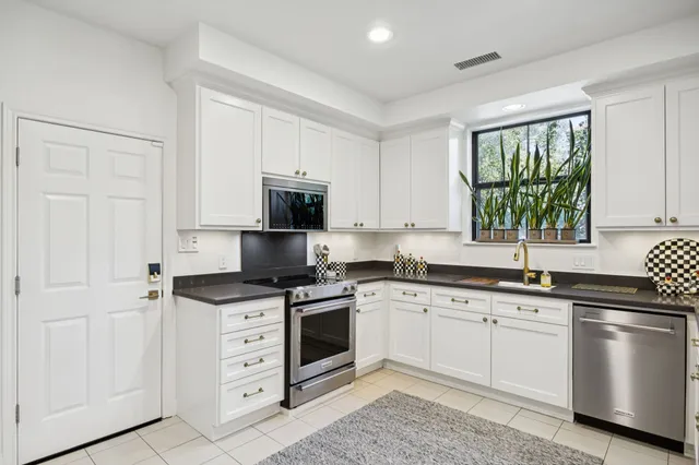 a kitchen with cabinets appliances a sink and a window