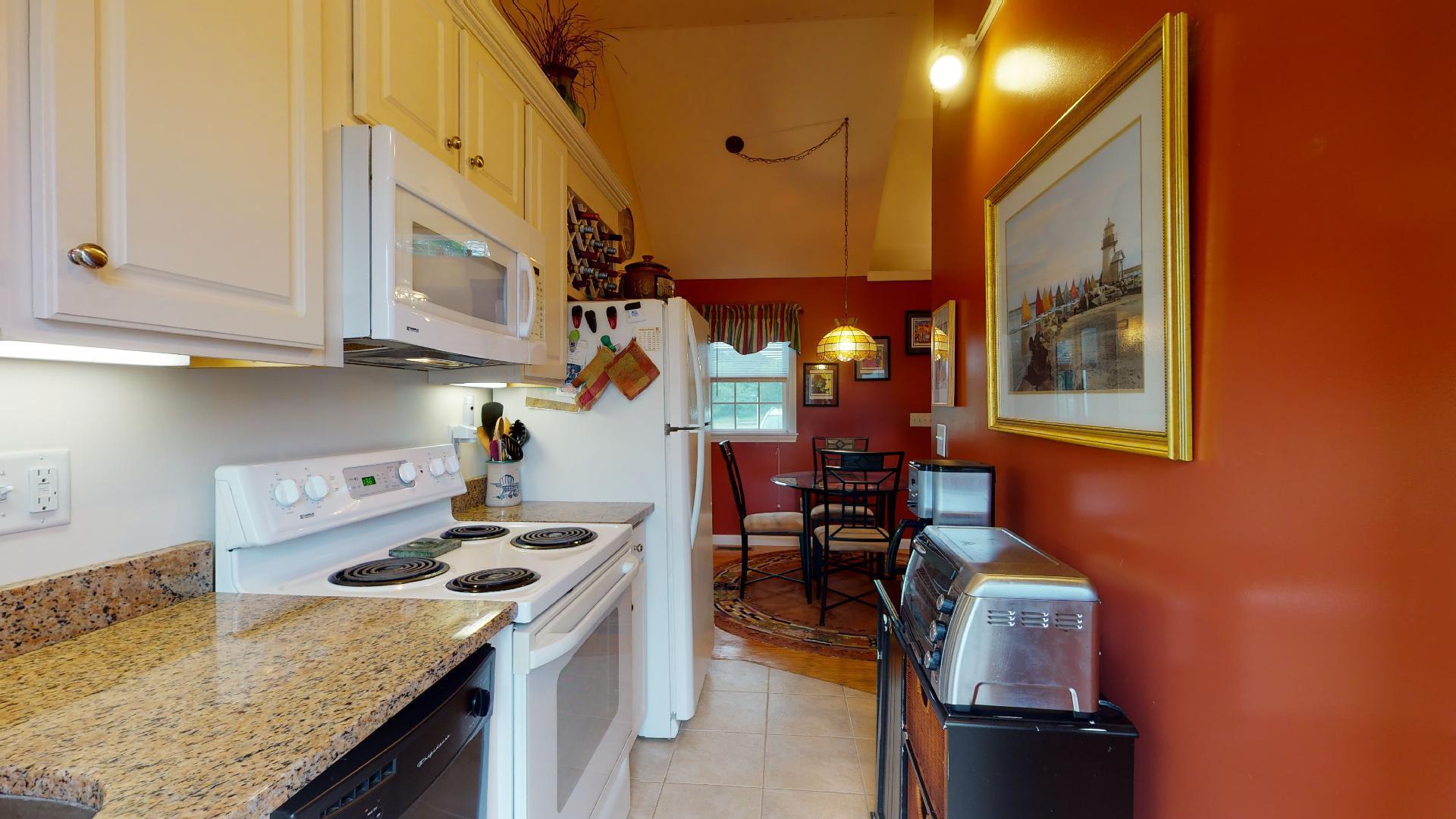6 Shore Road, Unit 24 Truro, MA 02666 - Photo 24 of 46 a kitchen with a stove and a refrigerator