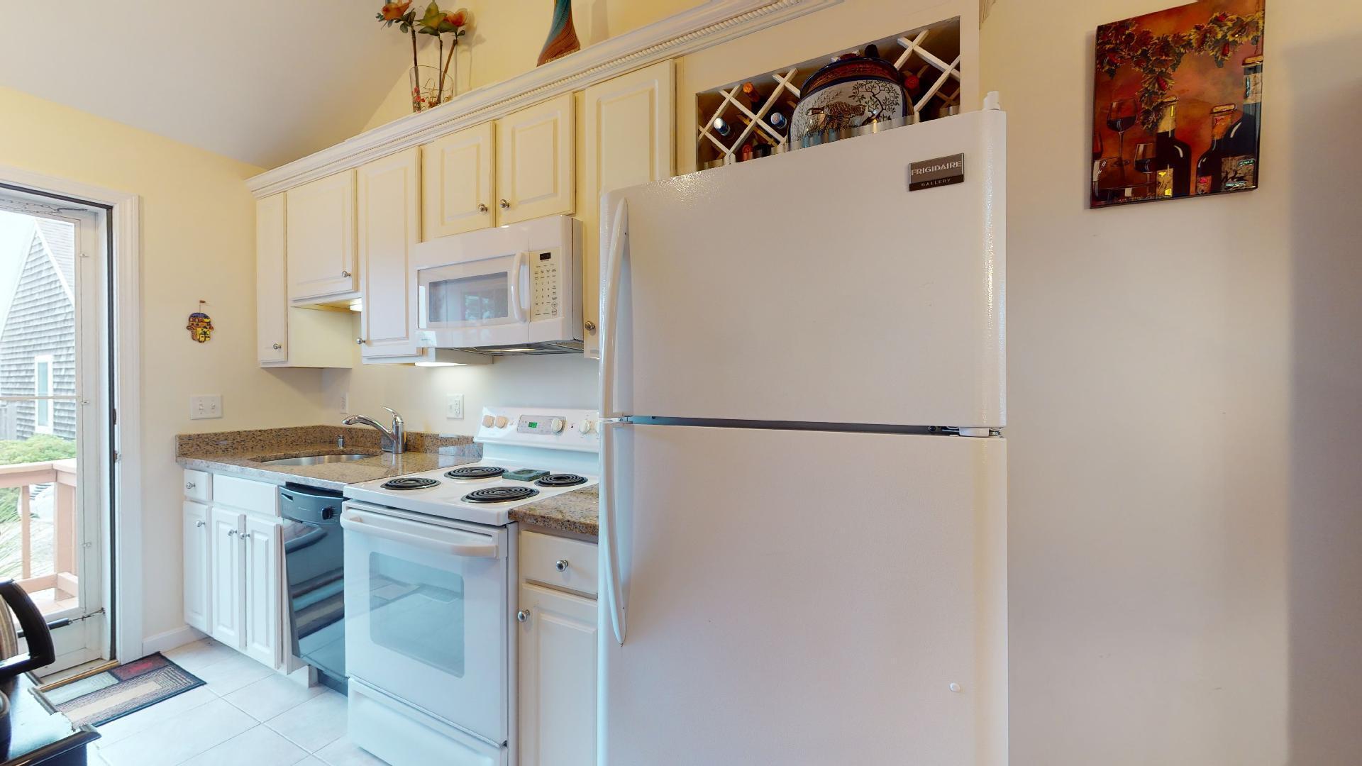 6 Shore Road, Unit 24 Truro, MA 02666 - Photo 26 of 46 a kitchen with stainless steel appliances a refrigerator a stove and white cabinets
