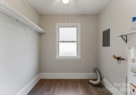 a view of a room with wooden floor a chandelier fan and windows