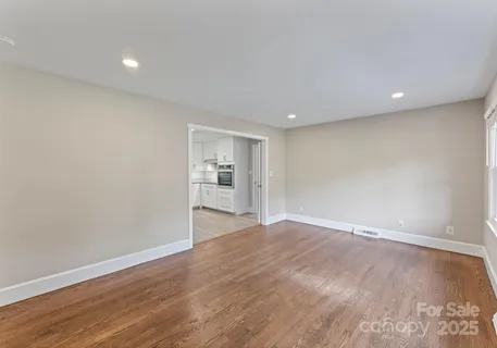 a view of empty room with wooden floor