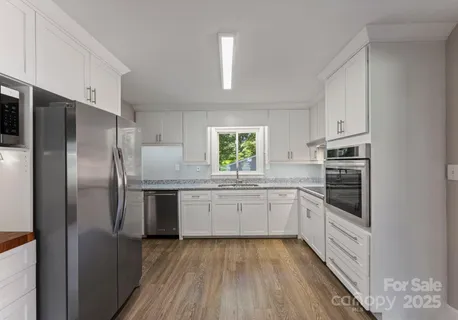 a kitchen with granite countertop stainless steel appliances a refrigerator and a sink