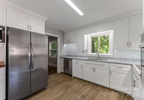 a kitchen with stainless steel appliances granite countertop a refrigerator and a sink
