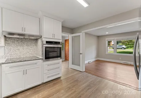 a kitchen with granite countertop a stove and cabinets
