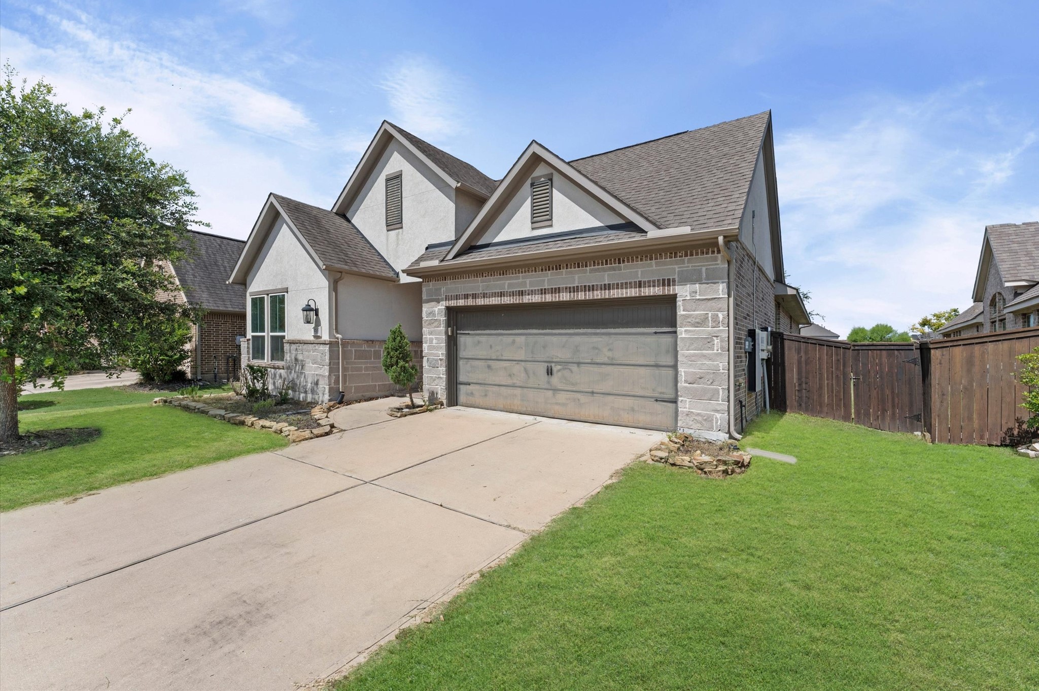 3510 Whitman Drive Rosharon, TX 77583 - Photo 24 of 25 Charming two-story home with a clean driveway, attached garage, and well-maintained lawn. The exterior features a combination of brick and siding, complemented by a wooden fence and a small landscaped garden.