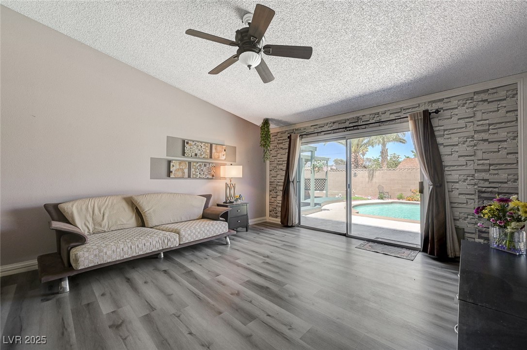 3266 Mountain Spring Road Las Vegas, NV 89146 - Photo 12 of 49 Sitting room with a ceiling fan, wood finished floors, a textured ceiling, baseboards, and lofted ceiling