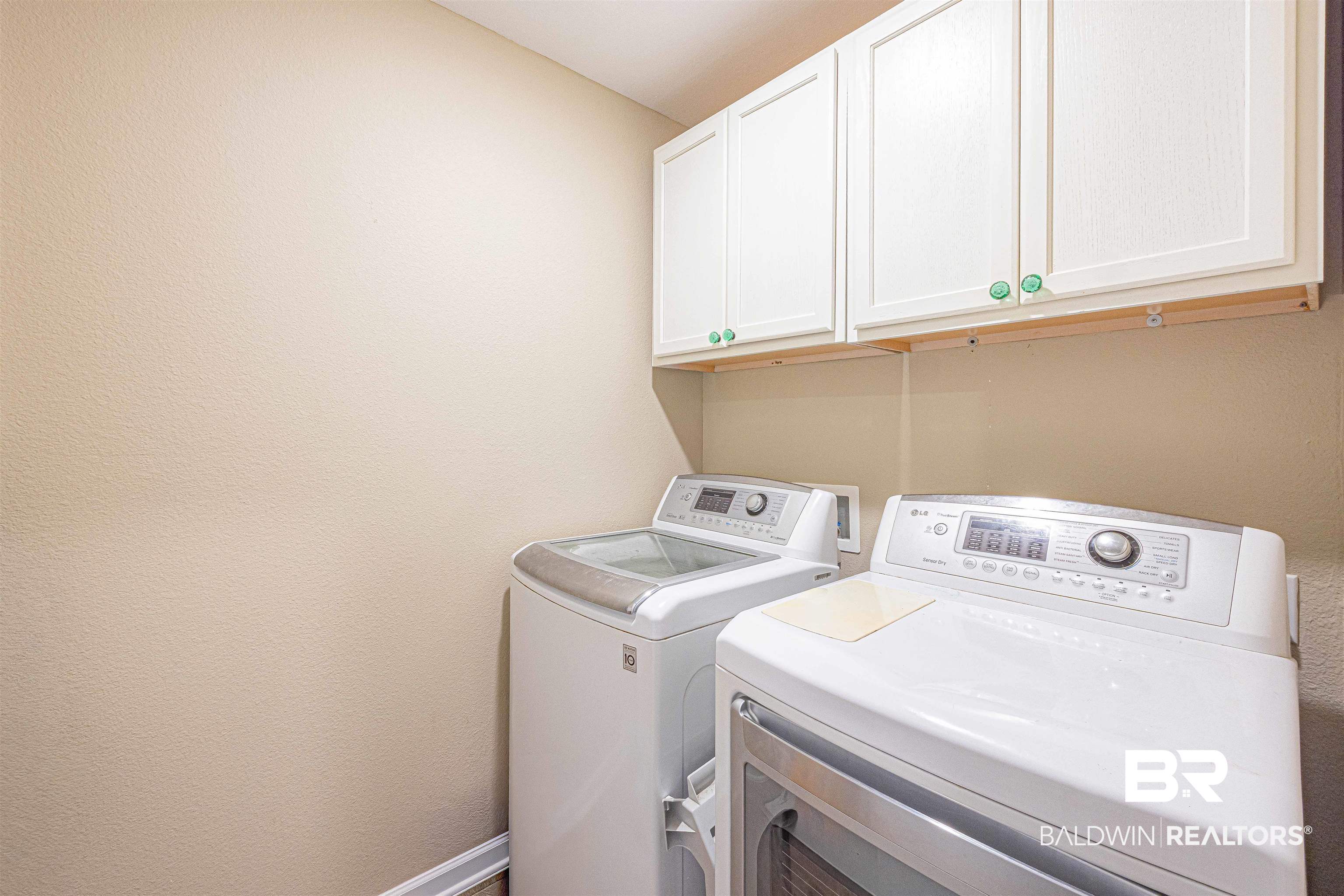 14843 Forsythia Loop Silverhill, AL 36576 - Photo 38 of 51 Laundry room featuring separate washer and dryer, cabinet space, and a textured wall
