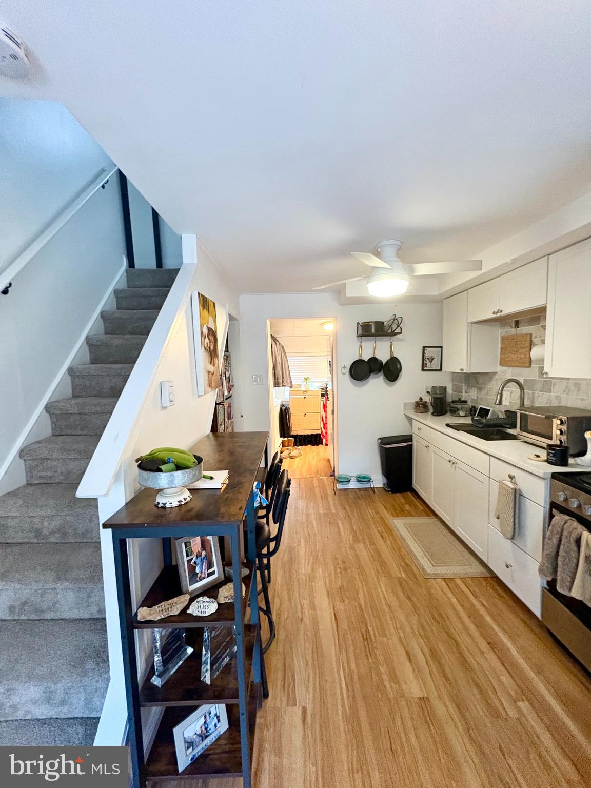 119 1/2 Maple Street, Unit 2 Conshohocken, PA 19428 - Photo 12 of 28 a kitchen with stainless steel appliances granite countertop a stove top oven a sink dishwasher and a dining table with wooden floor