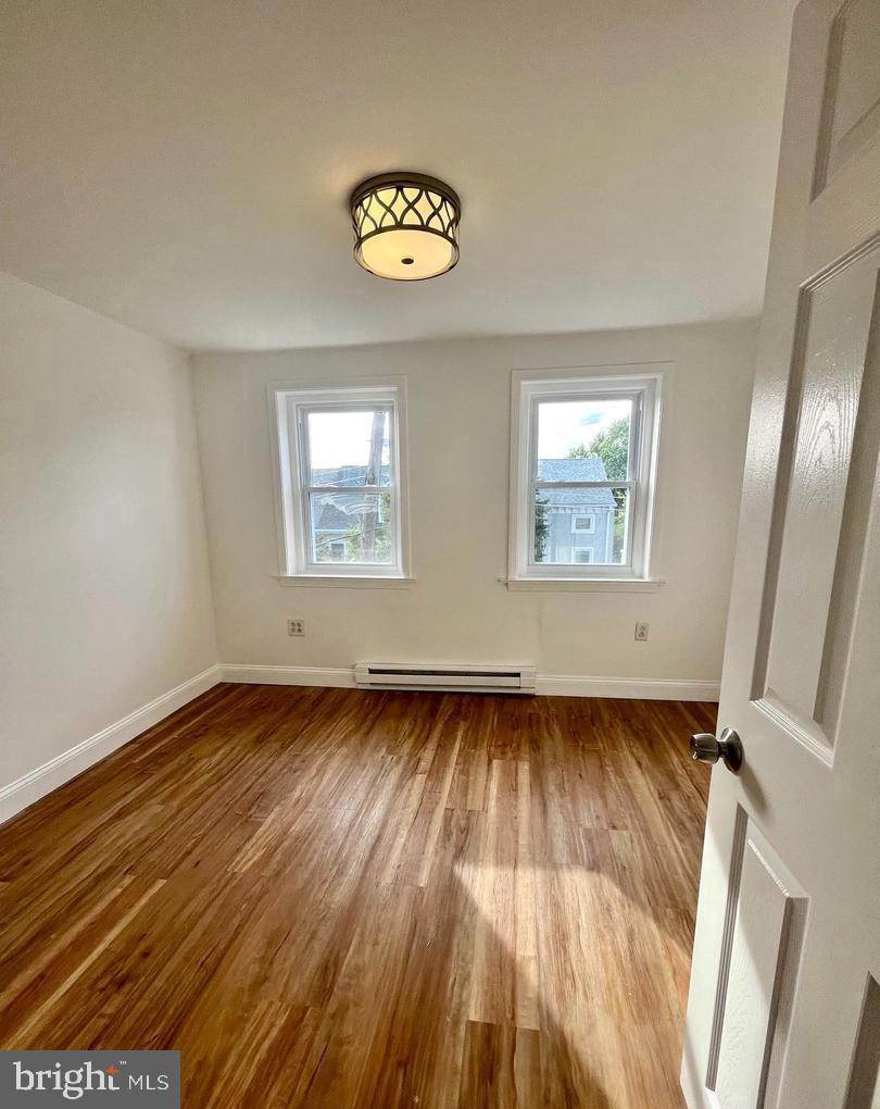 119 1/2 Maple Street, Unit 2 Conshohocken, PA 19428 - Photo 19 of 28 a view of an empty room with wooden floor and a window