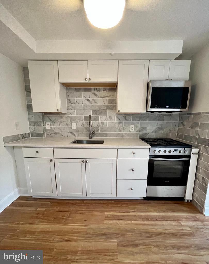 119 1/2 Maple Street, Unit 2 Conshohocken, PA 19428 - Photo 7 of 28 a kitchen with stainless steel appliances granite countertop a stove a sink and a microwave