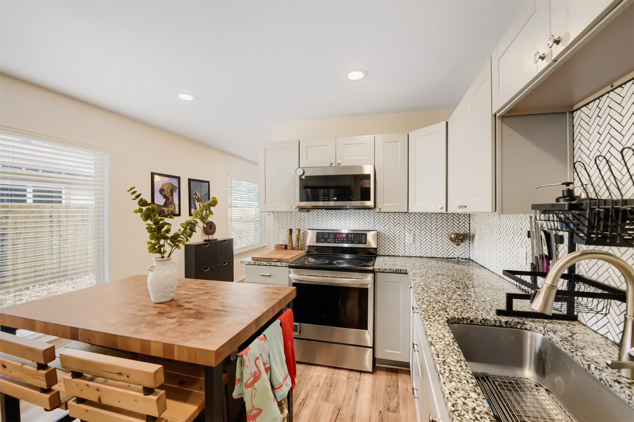 6105 Palm Circle Austin, TX 78741 - Photo 16 of 29 a kitchen with a stove a sink a microwave a dining table and chairs