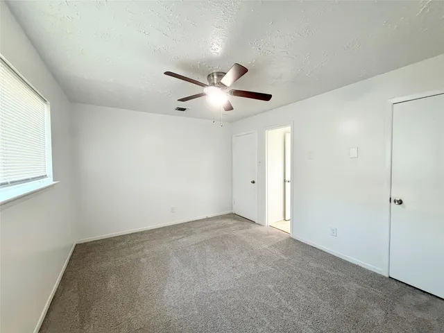 a spacious bathroom with a granite countertop sink a toilet and a mirror