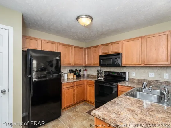 a kitchen with stainless steel appliances granite countertop a stove a refrigerator a sink a stove and dishwasher