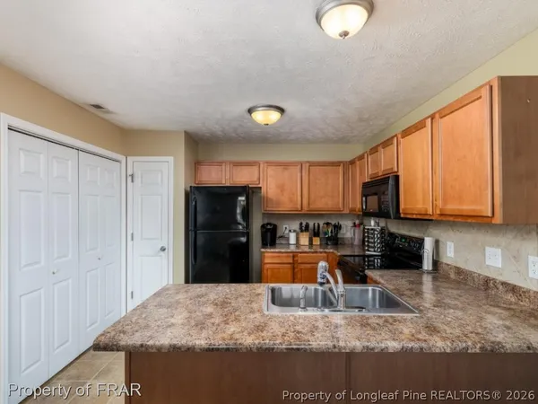 a kitchen with stainless steel appliances granite countertop a refrigerator a stove a sink dishwasher and white countertops with wooden floor
