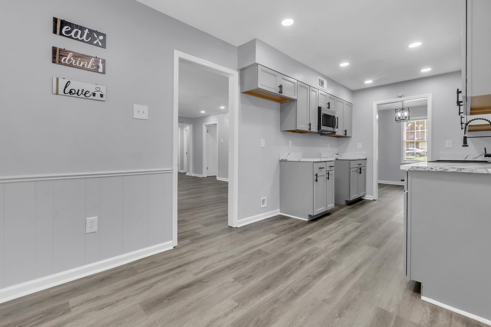 3314 Bright Ridge Cove Memphis, TN 38115 - Photo 7 of 16 Modern kitchen featuring light gray cabinetry, wood-finish flooring, recessed lighting, a built-in microwave, and a dark-toned faucet