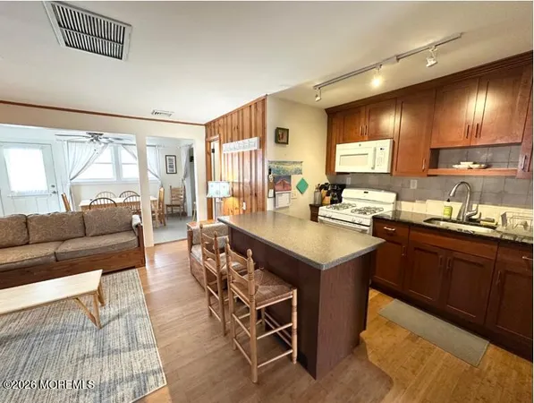 a dining room with wooden floor and furniture