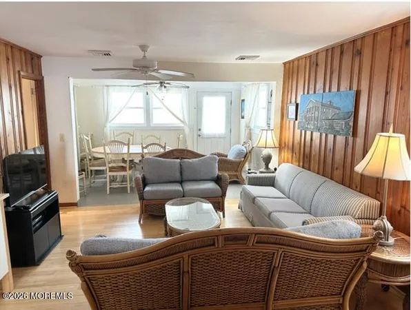 a living room with furniture a ceiling fan and a chandelier
