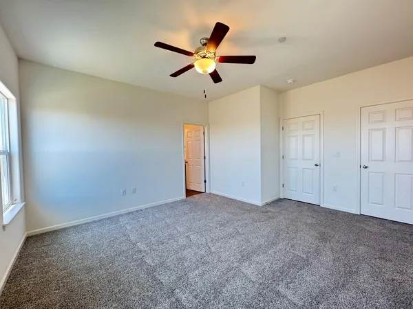an empty room with closet and windows