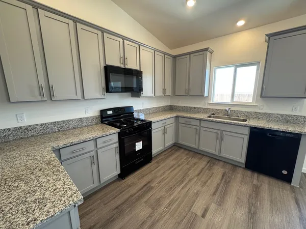 a kitchen with a sink a stove and cabinets