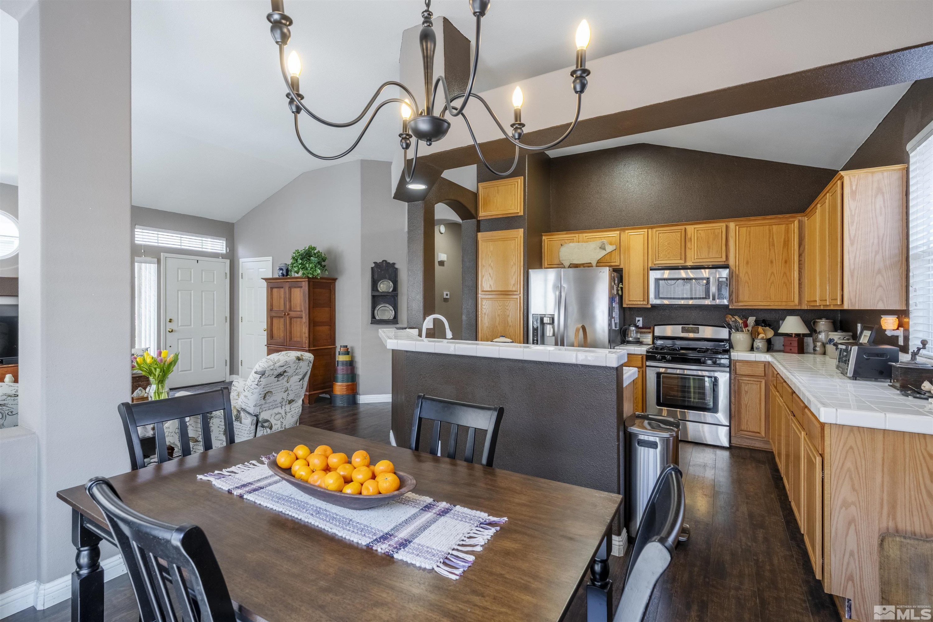 1236 Tule Drive Reno, NV 89521 - Photo 11 of 31 a kitchen with stainless steel appliances granite countertop a stove a refrigerator a oven a dining table and chairs with wooden floor