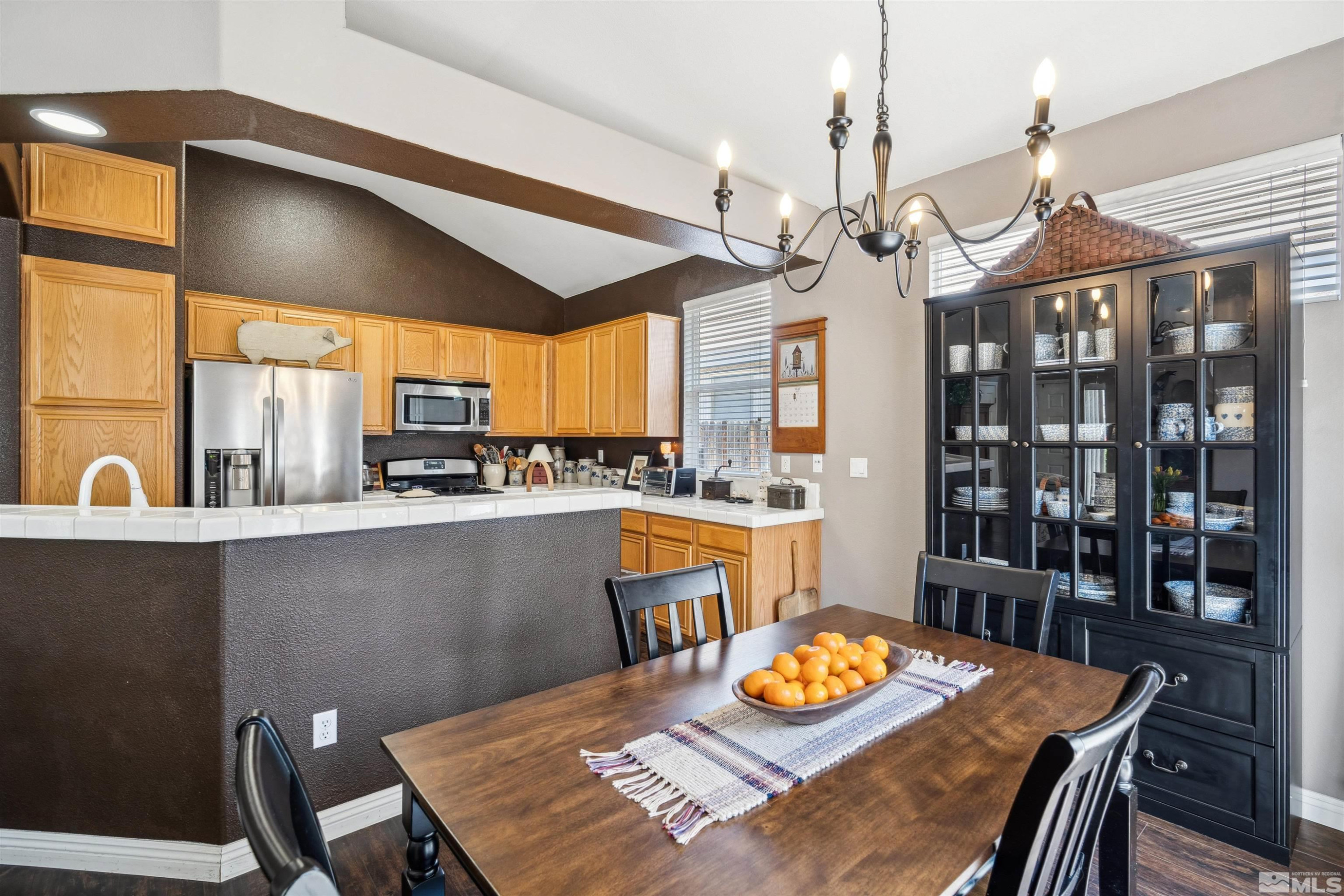 1236 Tule Drive Reno, NV 89521 - Photo 12 of 31 a view of a dining room with furniture a chandelier and wooden floor
