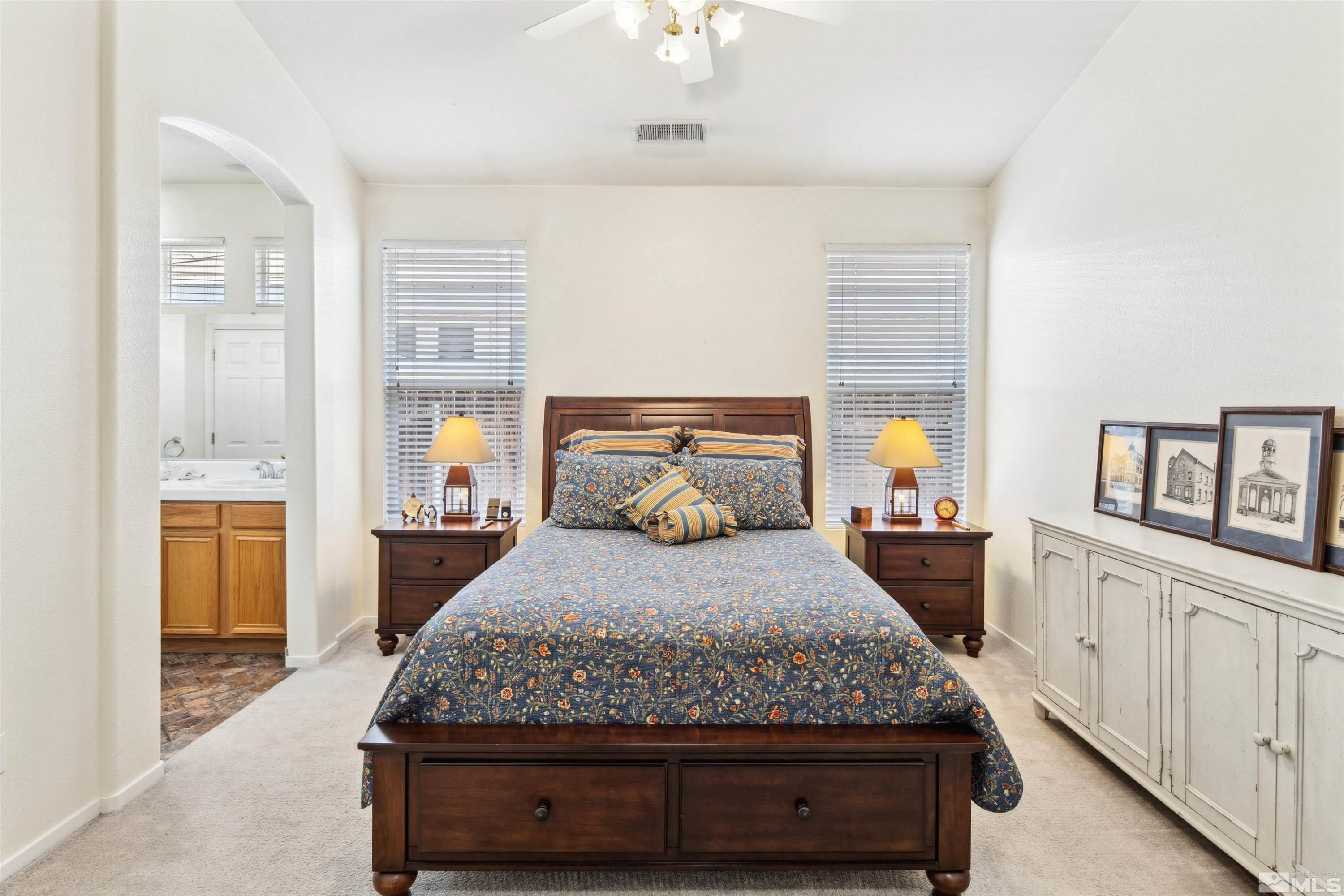 1236 Tule Drive Reno, NV 89521 - Photo 13 of 31 a bedroom with a large bed and a chandelier