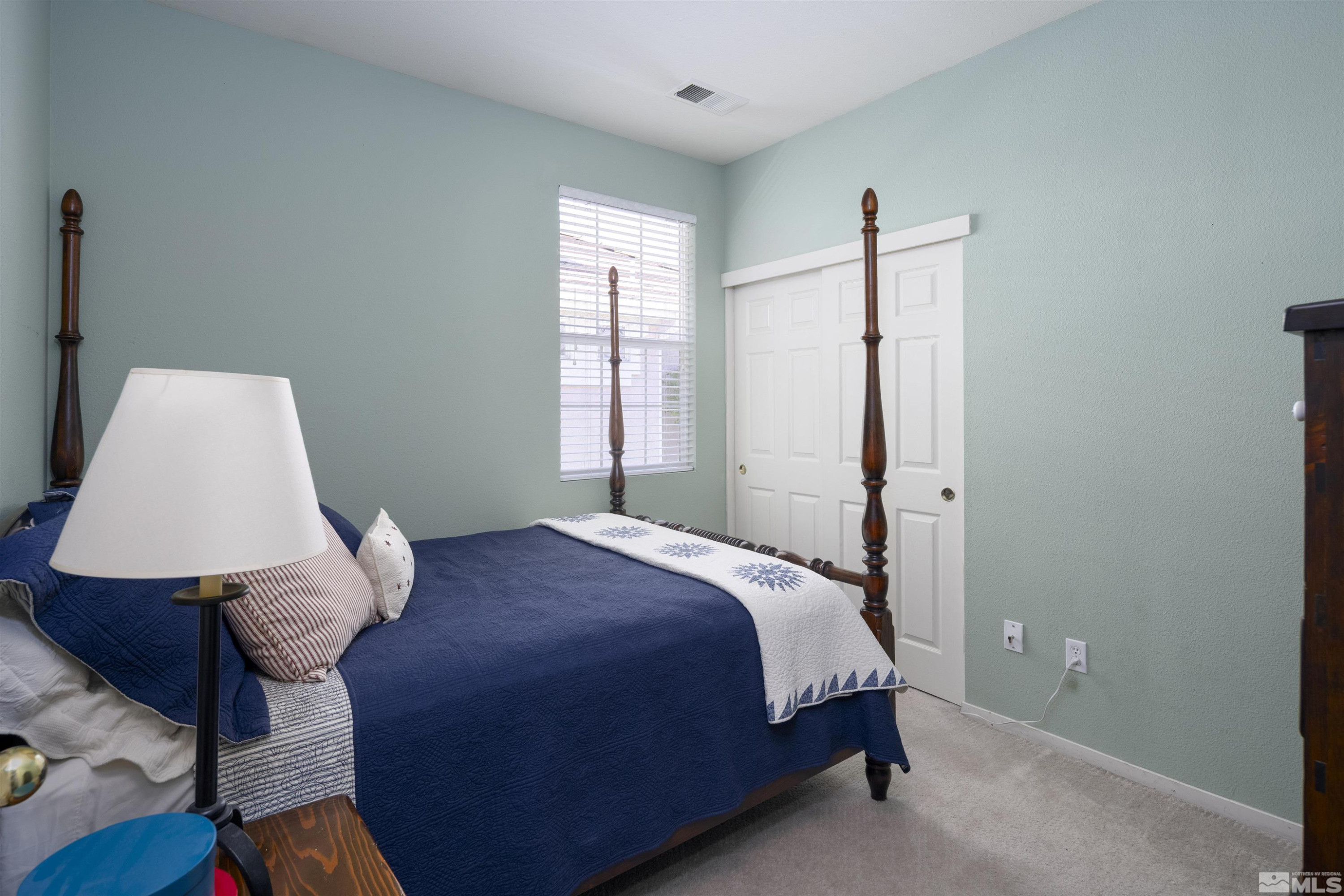 1236 Tule Drive Reno, NV 89521 - Photo 18 of 31 a bedroom with a bed lamp and a window