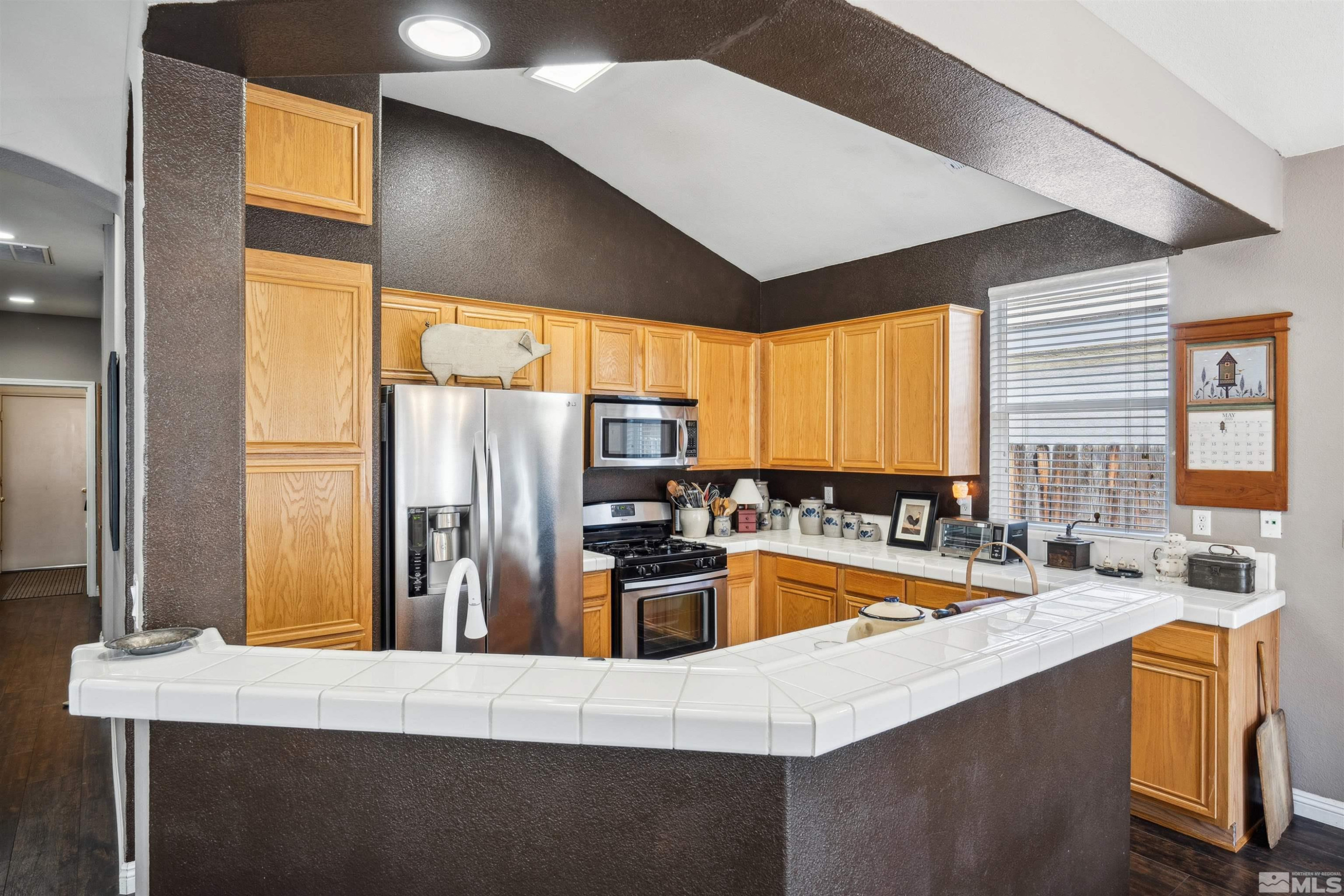 1236 Tule Drive Reno, NV 89521 - Photo 6 of 31 a kitchen with stainless steel appliances a sink a stove and a refrigerator