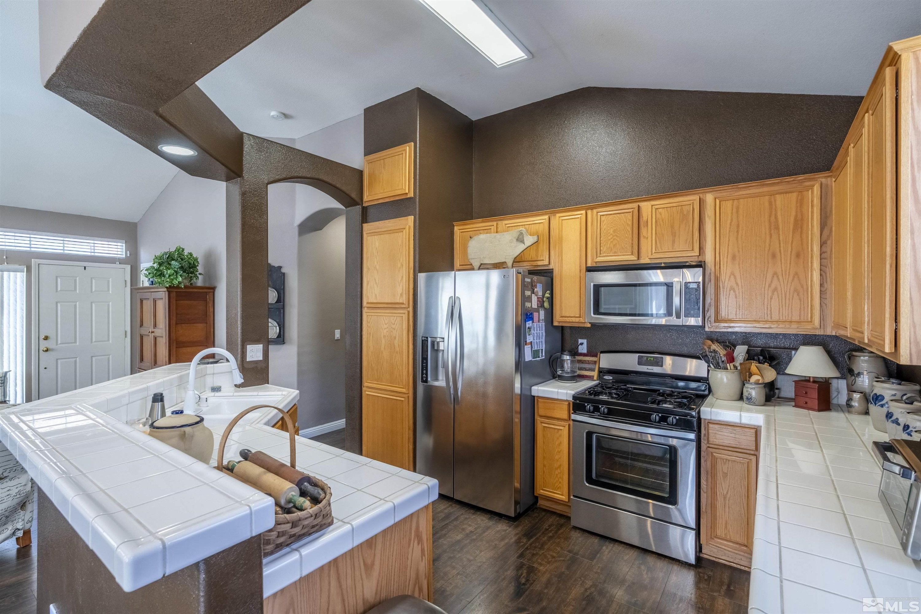 1236 Tule Drive Reno, NV 89521 - Photo 8 of 31 a kitchen with stainless steel appliances a stove a sink a microwave and refrigerator