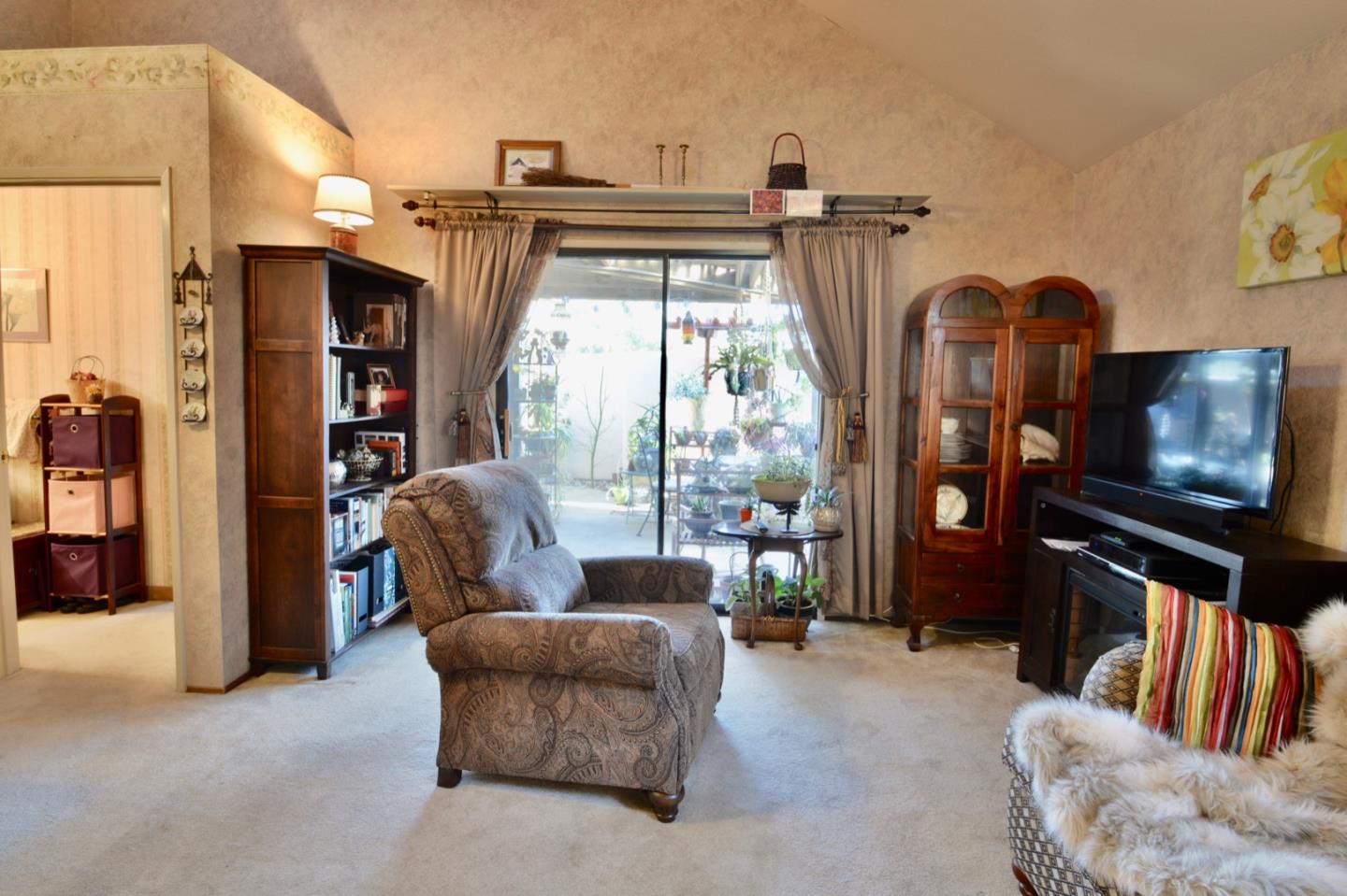 738 Natalie Drive Morgan Hill, CA 95037 - Photo 21 of 37 a living room with furniture a flat screen tv and floor to ceiling window