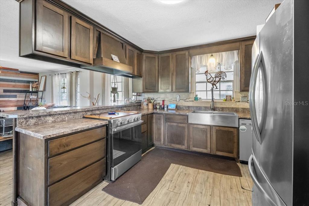 7422 County Road 231 Lake Butler, FL 32054 - Photo 14 of 57 a kitchen with stainless steel appliances granite countertop a stove sink and cabinets