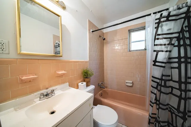 a bathroom with a sink a toilet a shower curtain and a bath tub