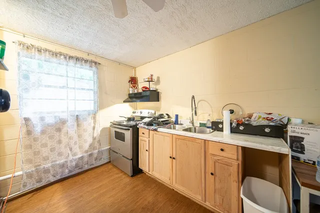 a kitchen with stainless steel appliances a sink a stove and white cabinets