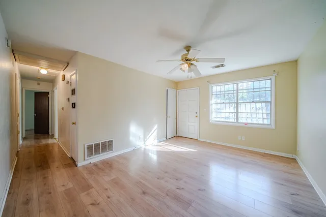 a view of a livingroom with wooden floor and a ceiling fan