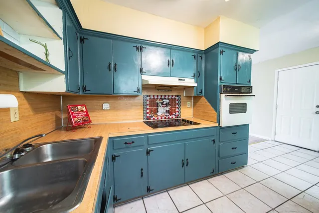 a kitchen with cabinets and steel appliances