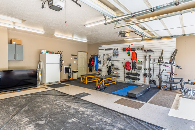 401 North Aoki Michi Road Brian Head, UT 84719 - Photo 46 of 58 Garage featuring overhead lighting, light-toned walls, a white overhead garage door, and a utility door