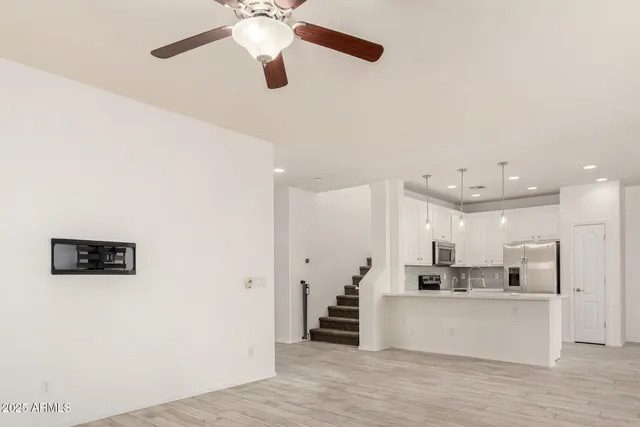 an empty room with a window and a fan