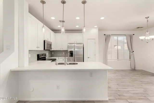an empty room with closet and a chandelier fan